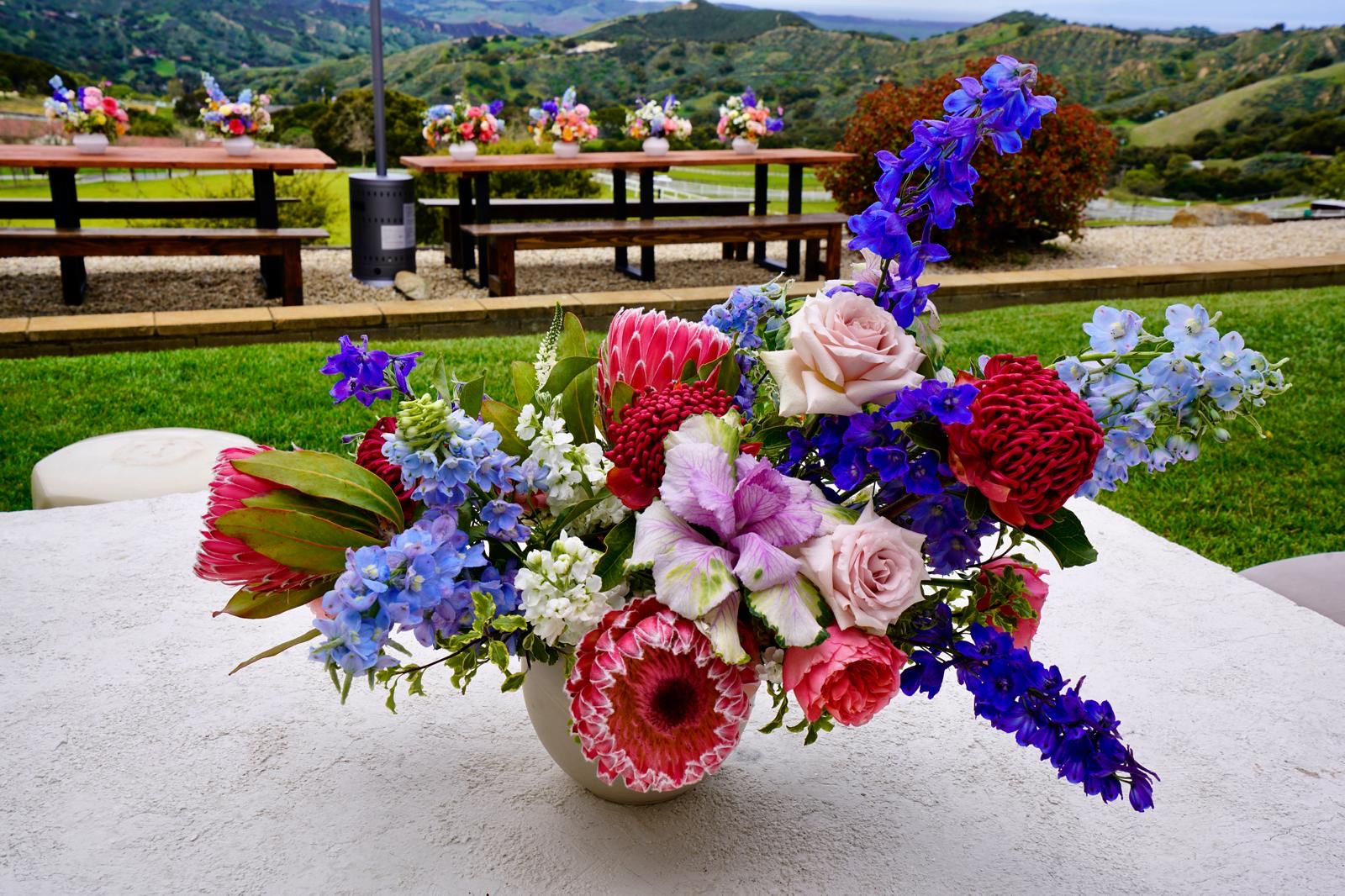 An elegant outdoor wedding reception table set with flowers