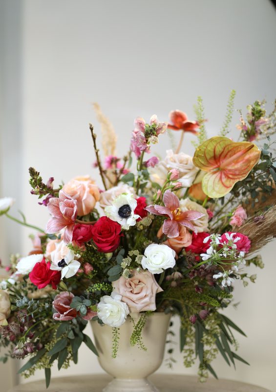 Coral urn with dahlias, vertical